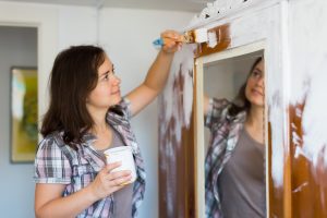 Woman Painting Mirror Wall in Closet 