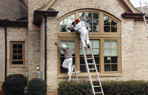 two painters working on a house