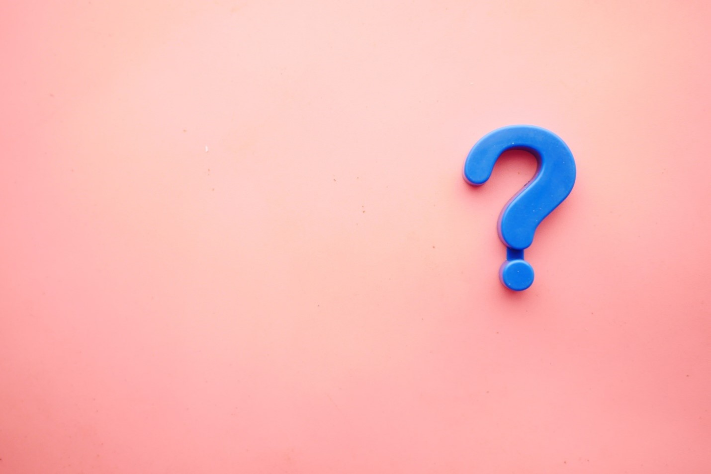 Blue question mark against light pink background