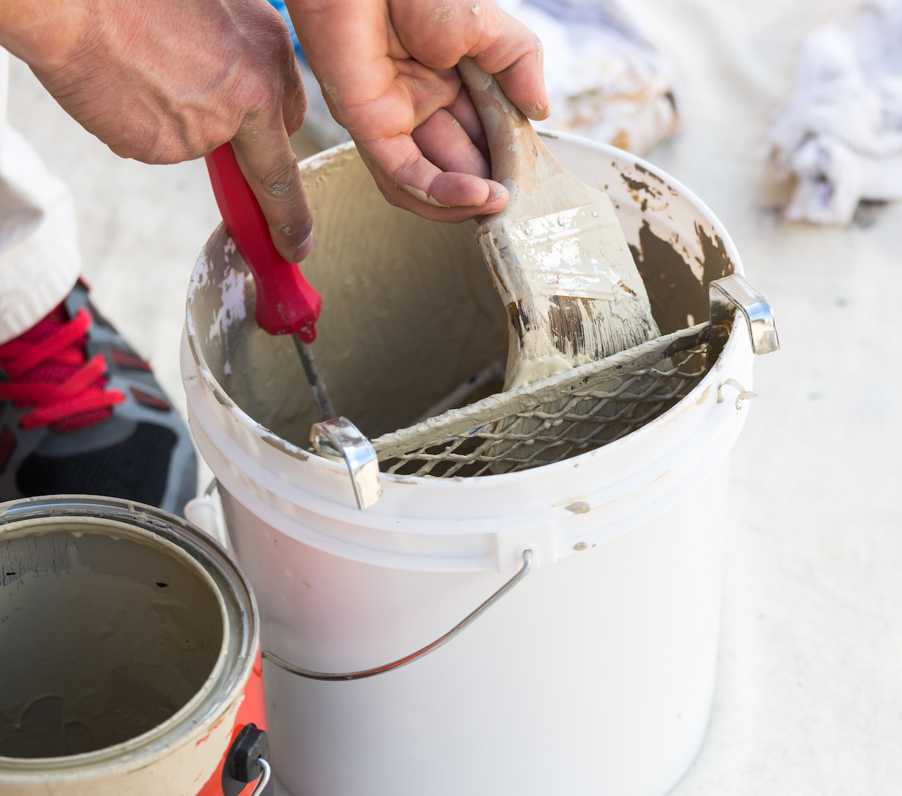 professional painter from painting company loading his brush with paint