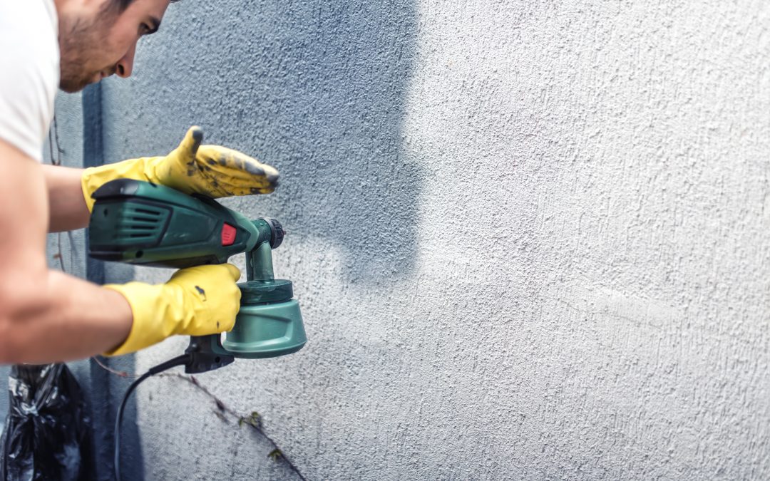 Man working on the exterior painting of his home